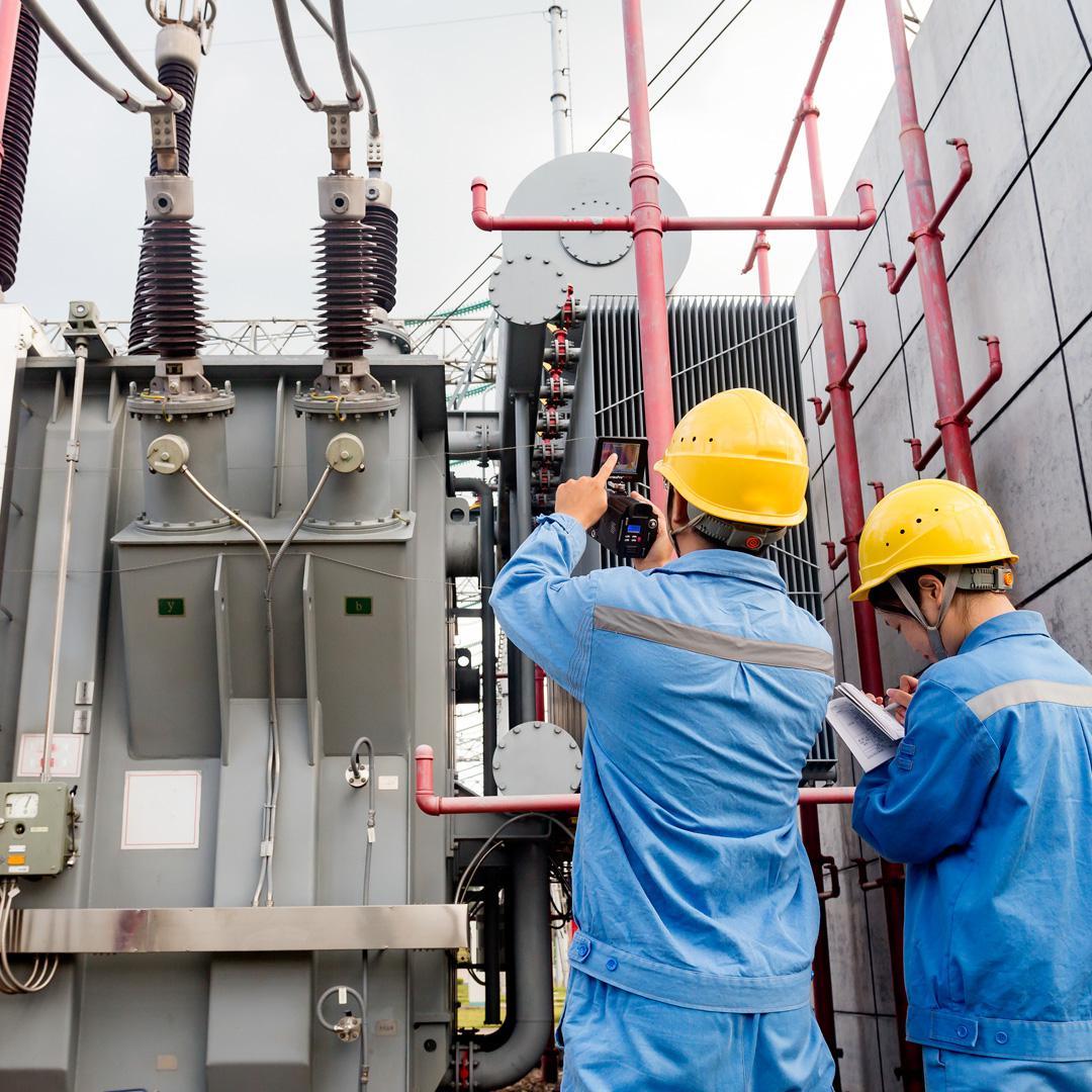 electrical technicians working on transformer inspection