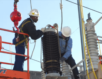 Image of two field techs examining a transformer.